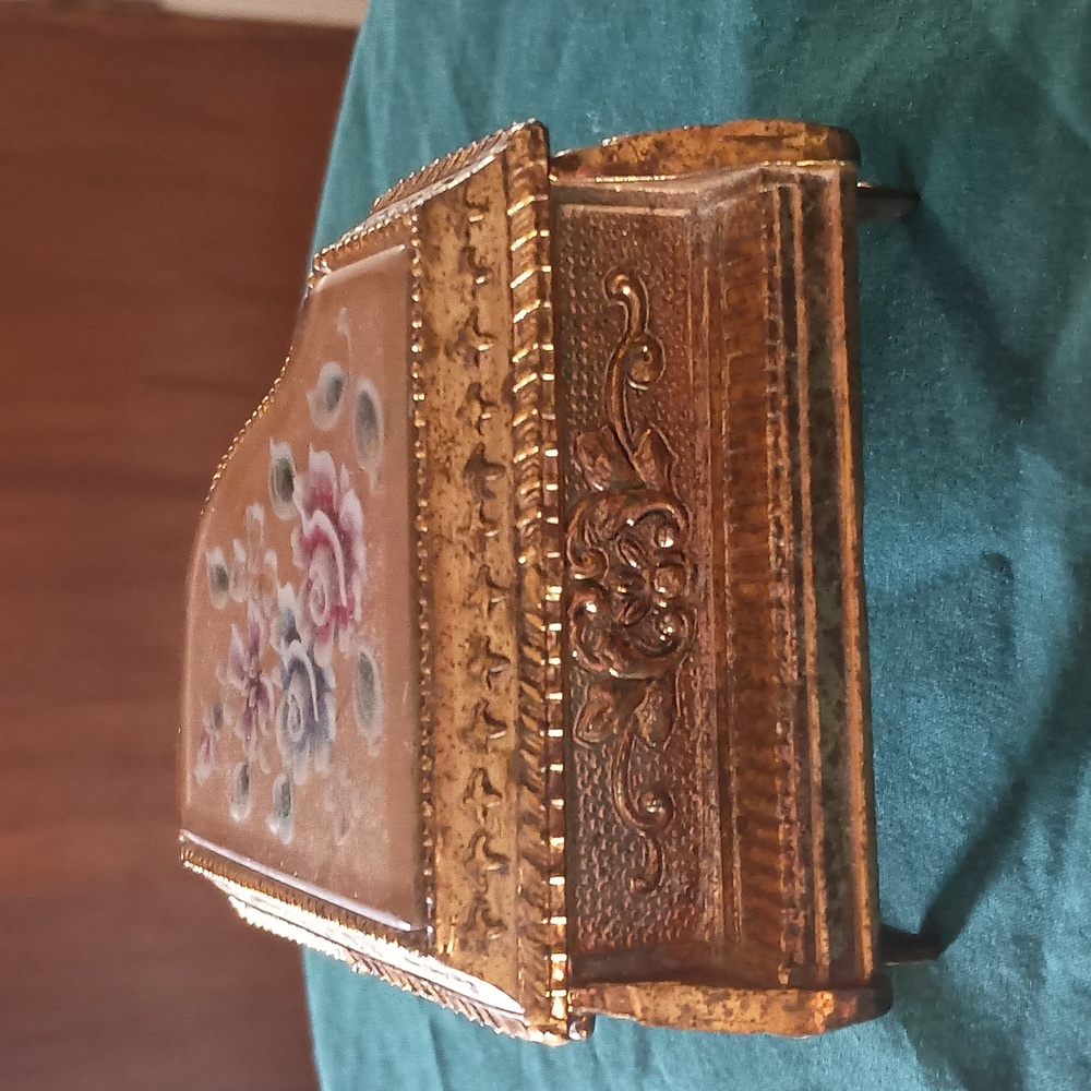 A vintage piano shaped with roses on top music box